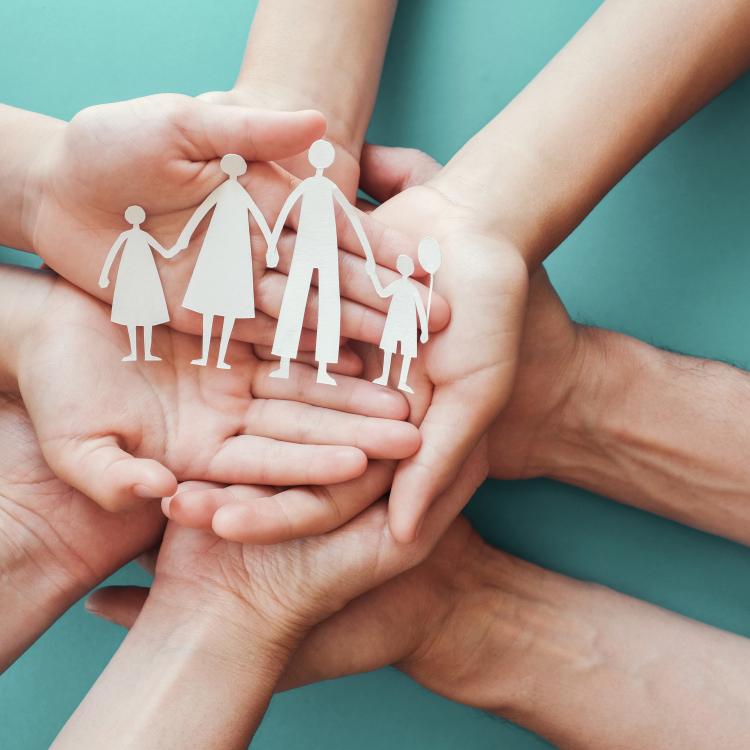  Adult and children hands holding paper family cutout